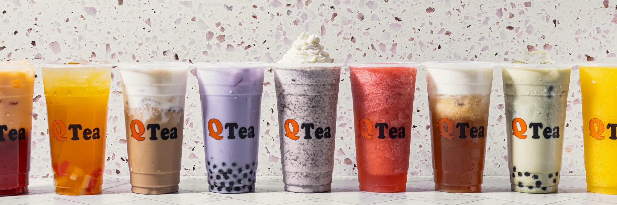 A row of Qtea drinks: fruit teas, milk teas, taro and an Oreo smoothie